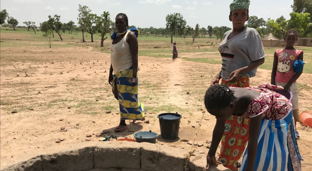 Mennesker ved en brønd i et tørt landskab i Afrika