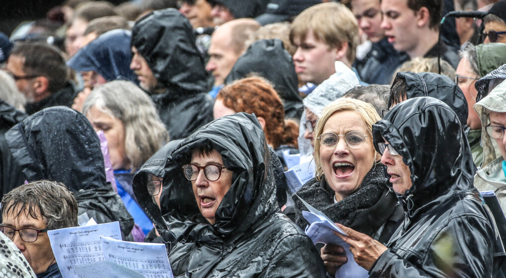Mennesker som synger i regnvejr ved Himmelske Dage